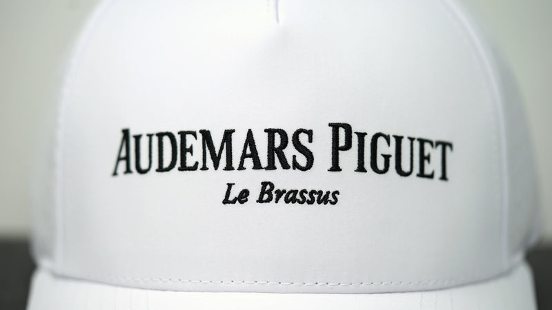 Close-up view of Audemars Piguet logo on white cotton hat