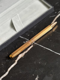 Side profile of Audemars Piguet Royal Oak yellow gold finish ballpoint pen showing brushed and polished surfaces