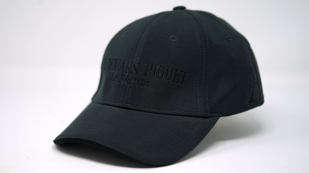 Angled shot of Audemars Piguet Royal Oak dark green baseball hat on flat surface