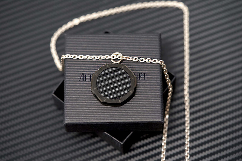 Stylish black Royal Oak medallion pendant positioned against matte background